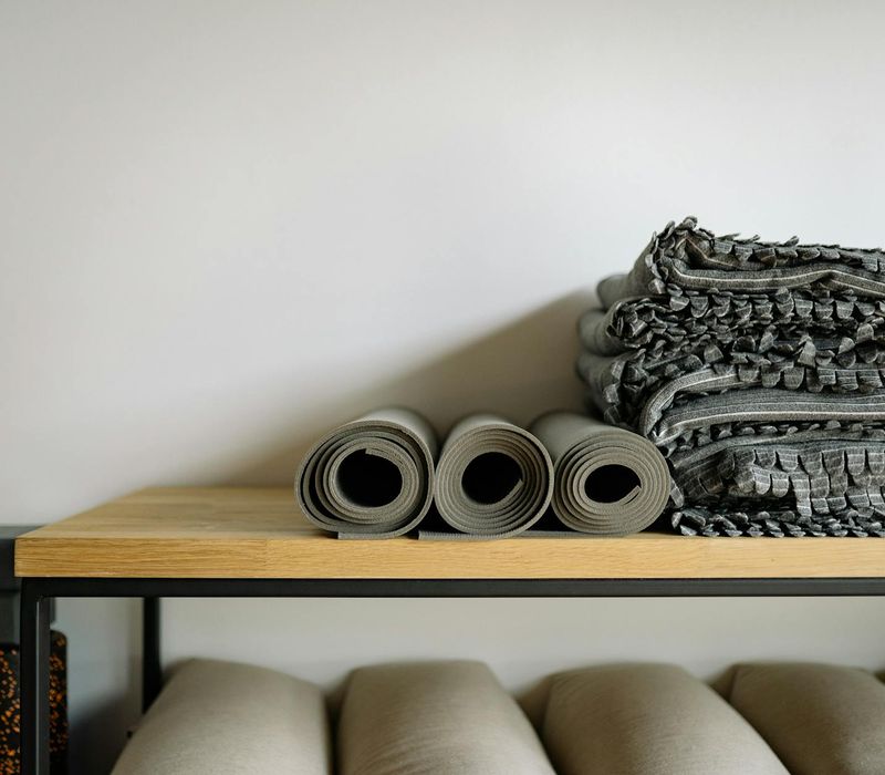 A neat arrangement of a yoga mat, a water bottle, and a small towel.