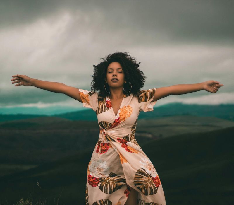Person feeling energized and happy, with arms outstretched towards the sky.